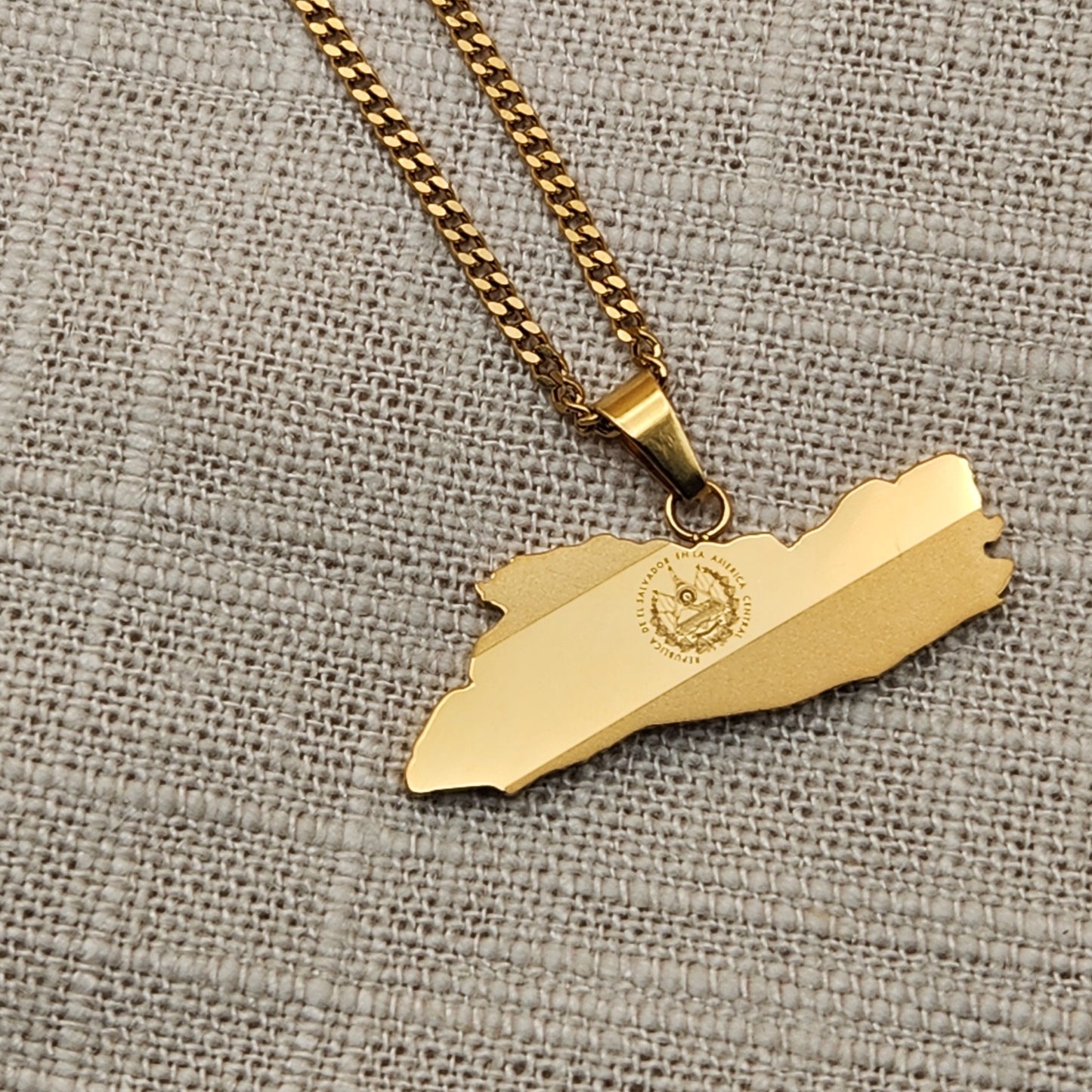 This is a 22 inch necklace made of 18k gold plated stainless steel. It feature a pendant shaped as the country El Salvador with the country's flag etched into the pendant.